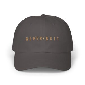 Never Quit Dad Cap with embroidered motivational text on a dark green baseball hat